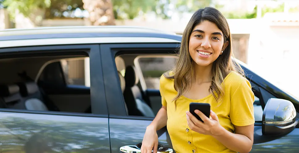 Smiling woman leaning on car