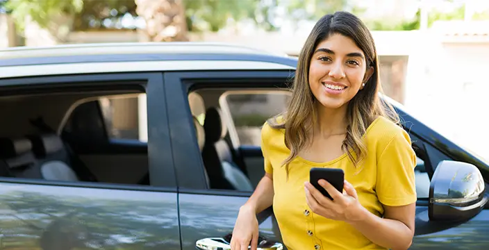 Smiling woman leaning on car